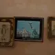 Photographs of Jorge Vazquez, left, and his brother Orlando Vazquez flank an image of the Statue of Liberty in New York, inside the home of their mother Catalina Vazquez in San Jeronimo Xayacatlan, Mexico, Thursday, June 25, 2020. Image by Fernando Llano/AP Photo. Mexico, 2020.<br />
