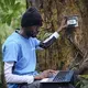 Kafuti performs some dendrochronology, measuring the minute-by-minute growth of the trees. Image by Sarah Waiswa. Democratic Republic of Congo, 2019.