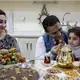 Dr. Faris offers his granddaughter, Elena Faris, 3, a strawberry after dinner with his daughter, Dr. Jumana Mohammed, left, and the rest of his family at his home in Erbil, Iraqi-Kurdistan on Feb. 5, 2019. Image by Brontë Wittpenn. Iraq, 2019.