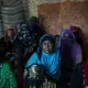 Yemeni women from the Warazan area of Taiz sit in a tent to escape the sun on April 23, 2018, in Mishqafa camp. Image by Alex Potter. Yemen, 2018. 